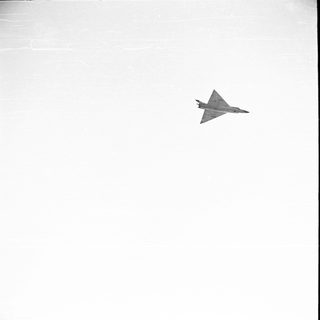 Fighter jet flying in a white sky.