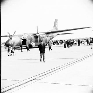 Man stands near Marine transport plane on airfield.