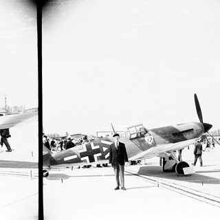 German fighter planes on display with people observing.