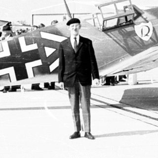 German fighter planes on display with people observing.