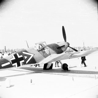 German fighter plane on airfield, wartime scene.