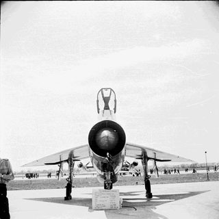 Black and white image of a military jet on display.