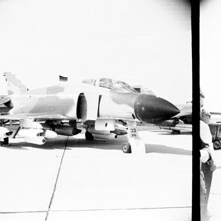 F-4 Phantom fighter jet on an airfield with personnel.