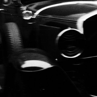 Vintage car and man standing near a building.