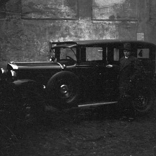Vintage car parked next to a textured wall.