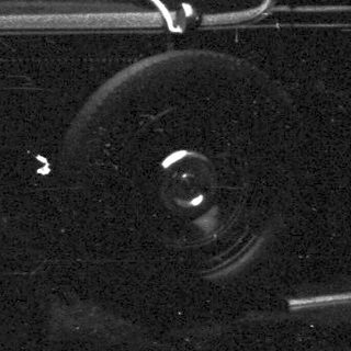 Vintage car parked next to a textured wall.