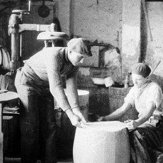 Two men working in a vintage industrial setting.