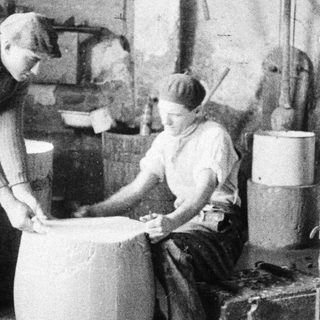 Two men working in a vintage industrial setting.