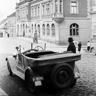 Vintage Jeep parked in front of a large building.
