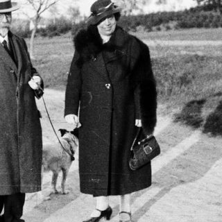 Couple walks dog along a country road.