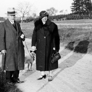 Couple walks dog along a country road.