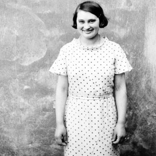 Young woman in a dress smiles for a portrait.