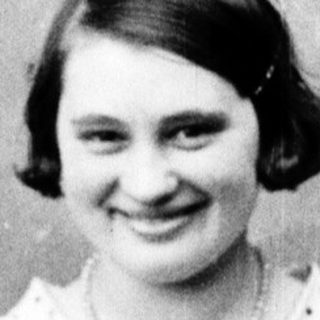 Young woman in a dress smiles for a portrait.