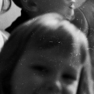 Group of children seated, looking upwards in a black and white photo.