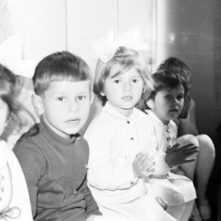 Group of children sitting together in a black and white photo.