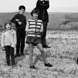 Black and white photo of a family in a field.