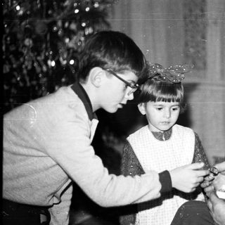Boy and older man affixing a hat to a child.