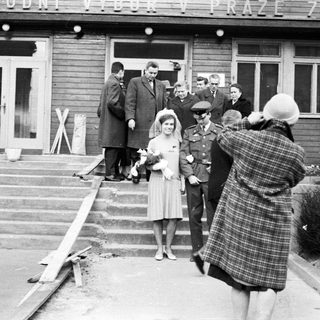 Woman in dress being photographed outside a building.