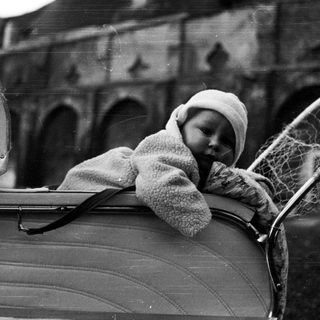 Baby in a vintage pram, monochrome photograph.