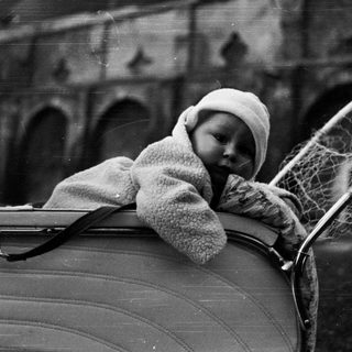 Baby in a vintage pram, monochrome photograph.