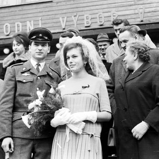 Bride and groom with family outside a building.
