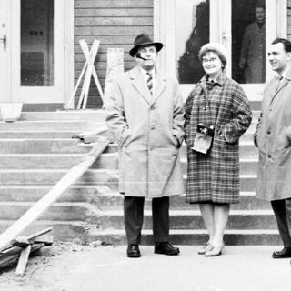 Three people stand outside a building in Prague.