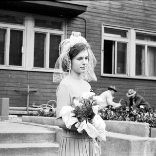 Black and white photo of a bride standing outside a building.