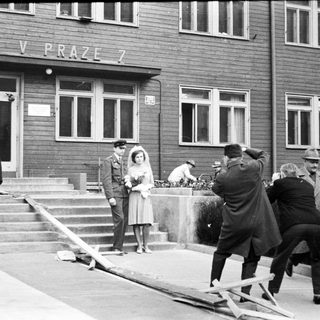 Couple poses for photo during construction in front of building.