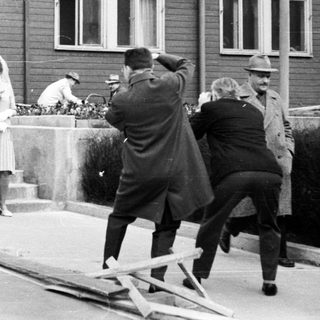 Couple poses for photo during construction in front of building.