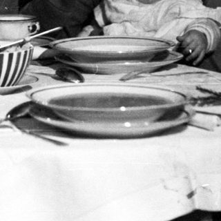 Family seated at a table, with a baby being held.