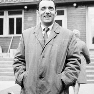 Man smiles in front of a building in Prague.