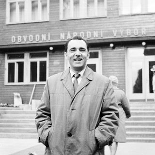 Man smiles in front of a building in Prague.