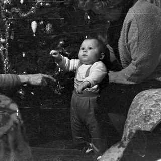 Family gathered near a decorated Christmas tree.