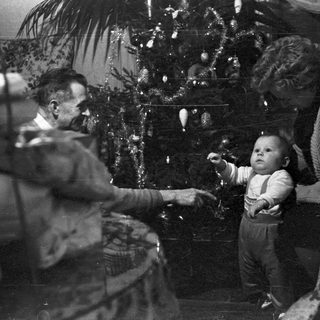 Family gathered near a decorated Christmas tree.