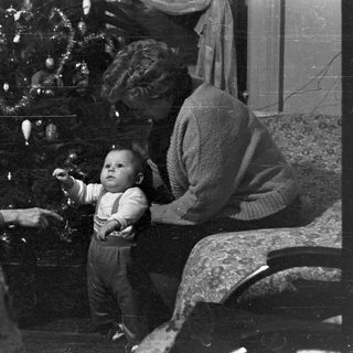 Family gathered near a decorated Christmas tree.