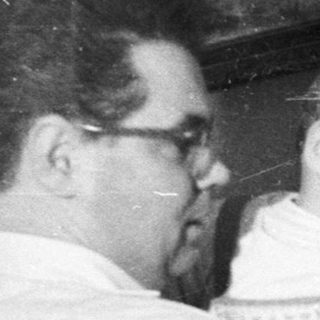 Man decorating a Christmas tree with a baby.