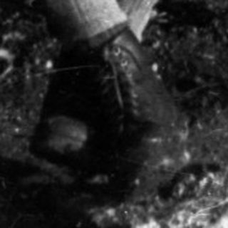 Man and boy seated on a weathered wooden bench.