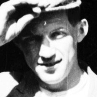 Man in hat salutes, standing in a doorway.