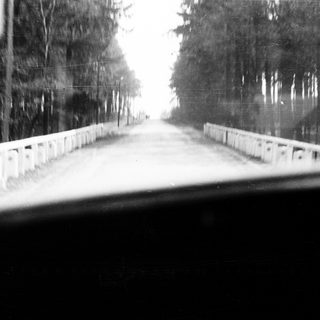 Road disappearing into distance, viewed from a vehicle.