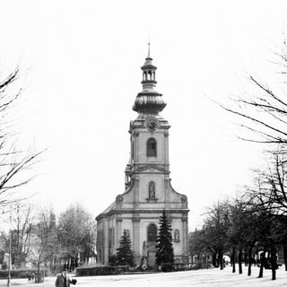 Black and white photo of a church tower with snow.