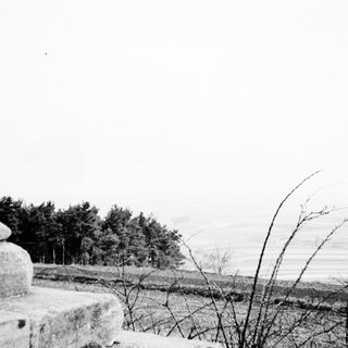 Stone structure overlooking a landscape with trees and fields.