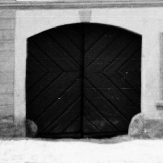 Black and white photo of a building with signage.