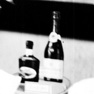 Table setting with wine bottles, glasses, and decorations.