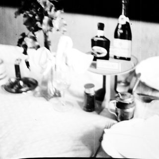 Table setting with wine bottles, glasses, and decorations.
