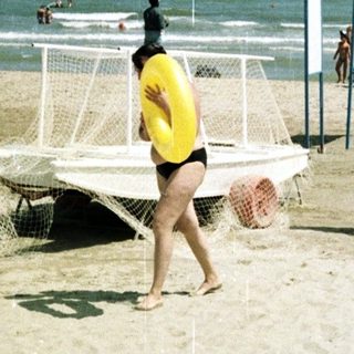 People enjoying a sunny day at a sandy beach.