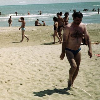 People enjoying a sunny day at a sandy beach.