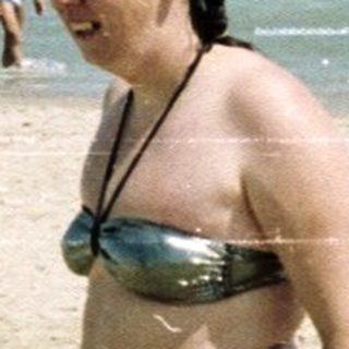 People on a beach with a woman holding a floatie.