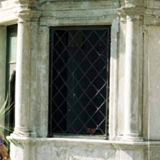 Woman stands in a square with historic buildings.