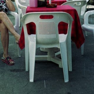 Woman seated at a table outside a hotel.