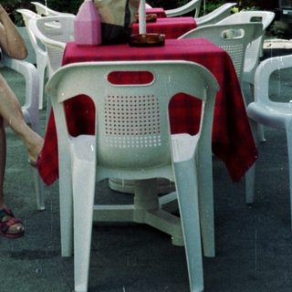 Woman seated at a table outside a hotel.